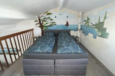 Schlafzimmer_Galerie_Boxspringbett_Meerblick_Palmen_Segelboot_Kunst